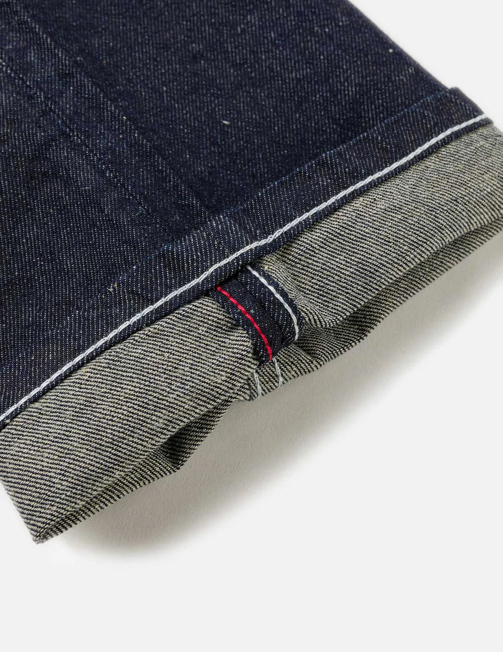 EVISU jeans med håndtrykt Daicock print i vaskede indigo, slim fit, vises med detaljeret visning af stoffet og design.