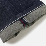 EVISU jeans med håndtrykt Daicock print i vaskede indigo, slim fit, vises med detaljeret visning af stoffet og design.