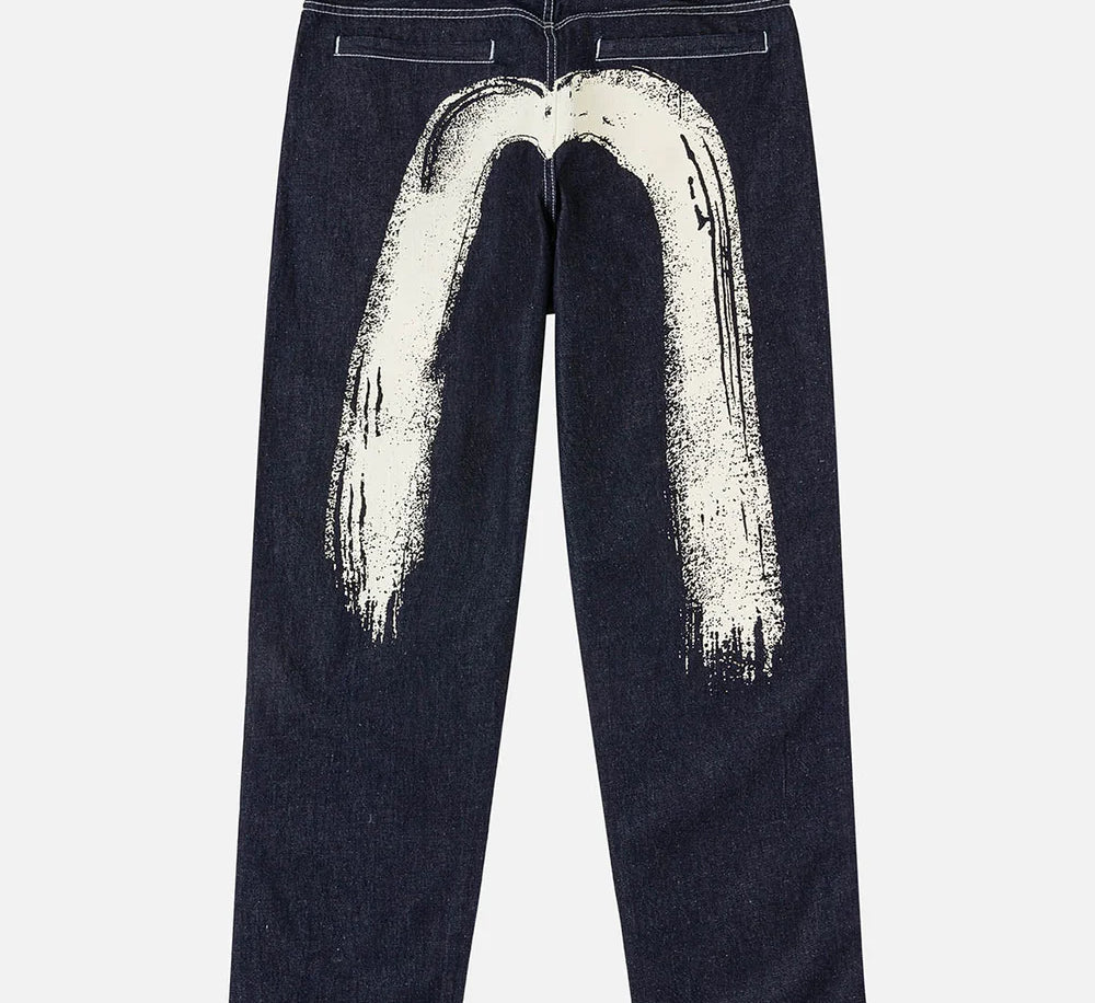 EVISU jeans med håndtrykt Daicock print i vaskede indigo-farver, vises med detaljeret stofstruktur og klassisk pasform.