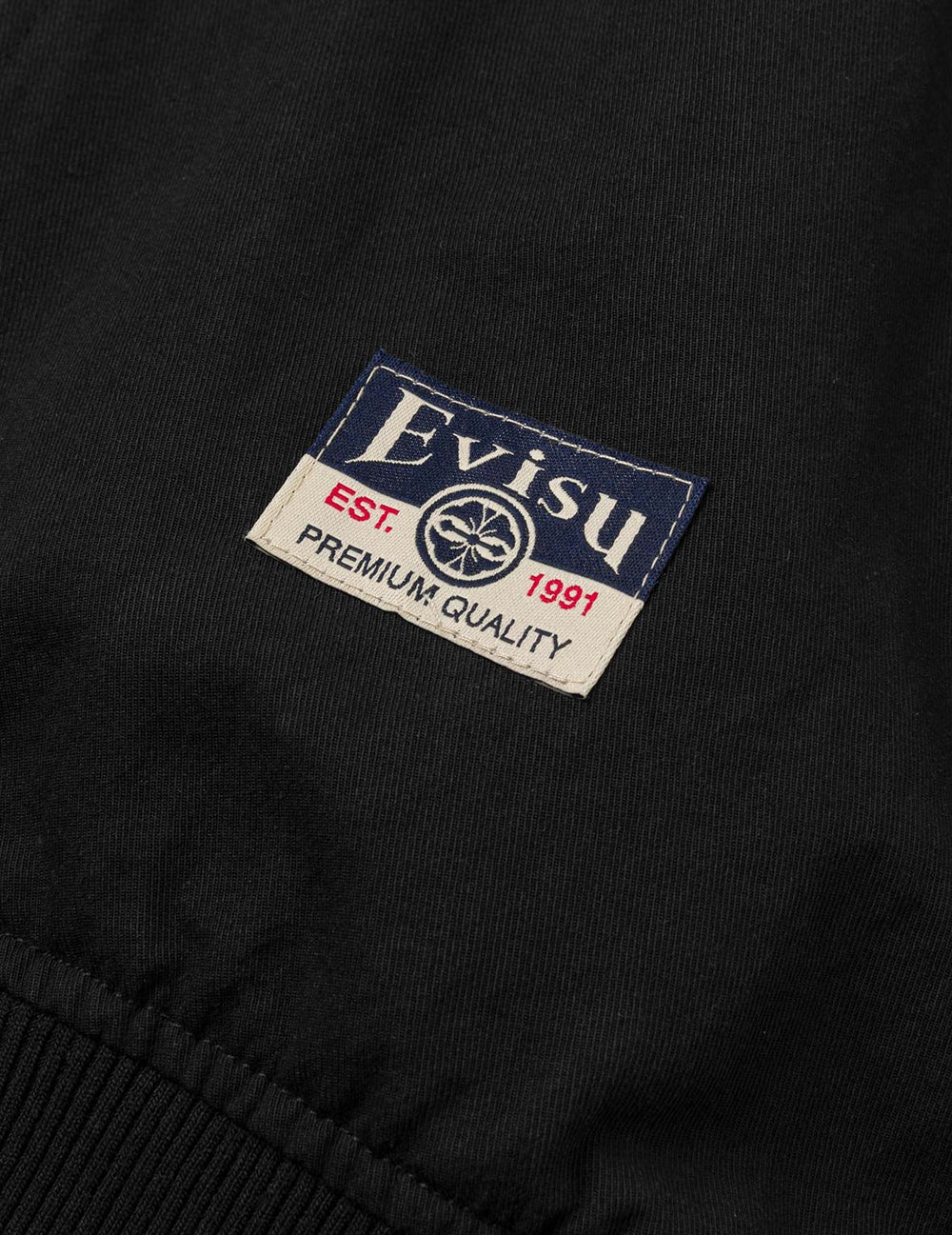 Sort EVISU-bomberjakke med Daicock-print og slidstærkt stof, vist med lynlås og ribkant.
