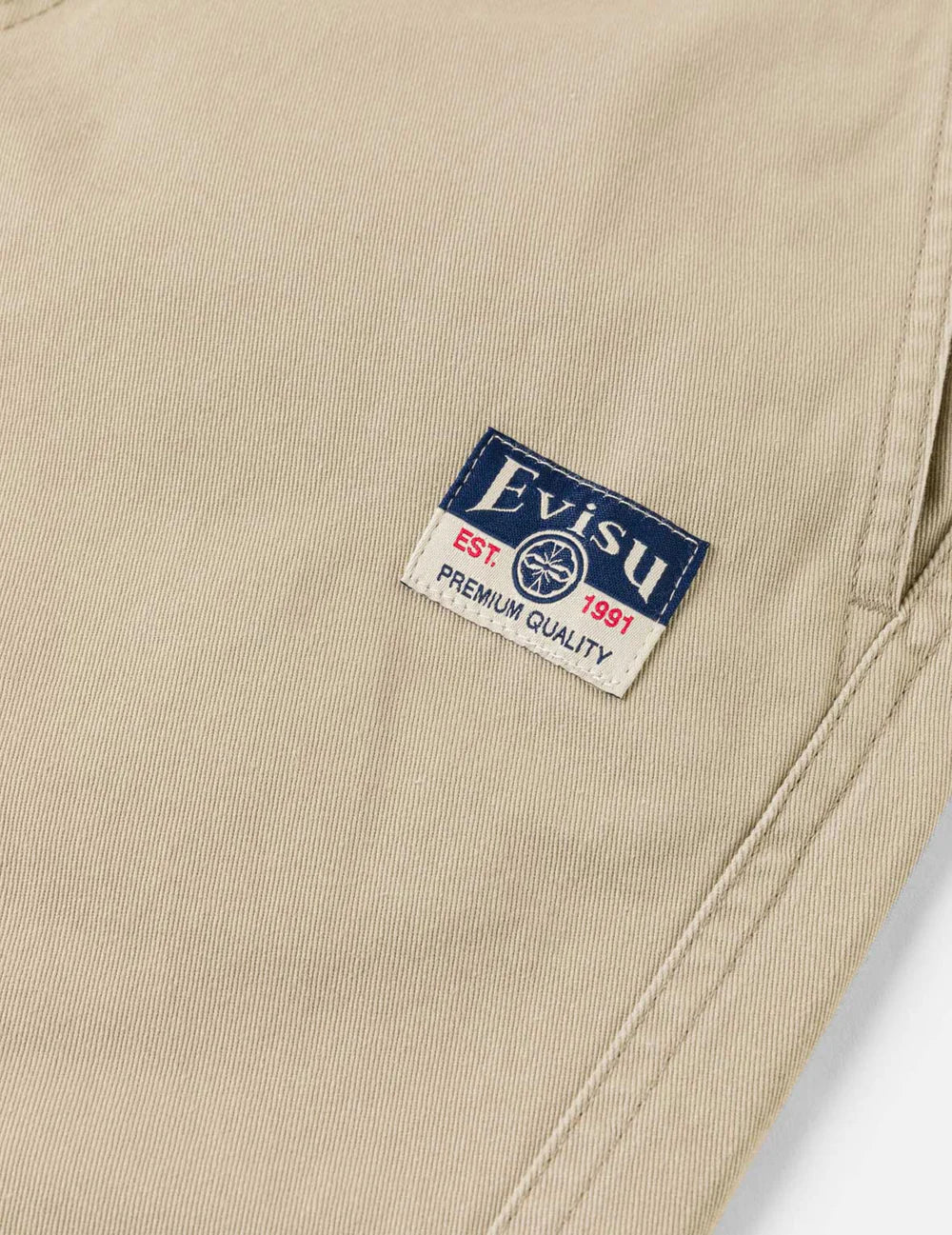 Beige EVISU shorts med seagull print, vævet design, afslappet pasform, perfekt til sommer- og fritidstøj.