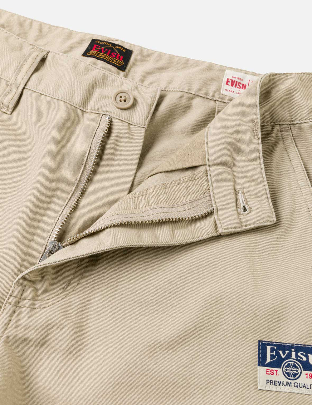 Beige EVISU shorts med sejlgullsprint, vævet stof og afslappet pasform, ideelle til sommer- eller casual brug.