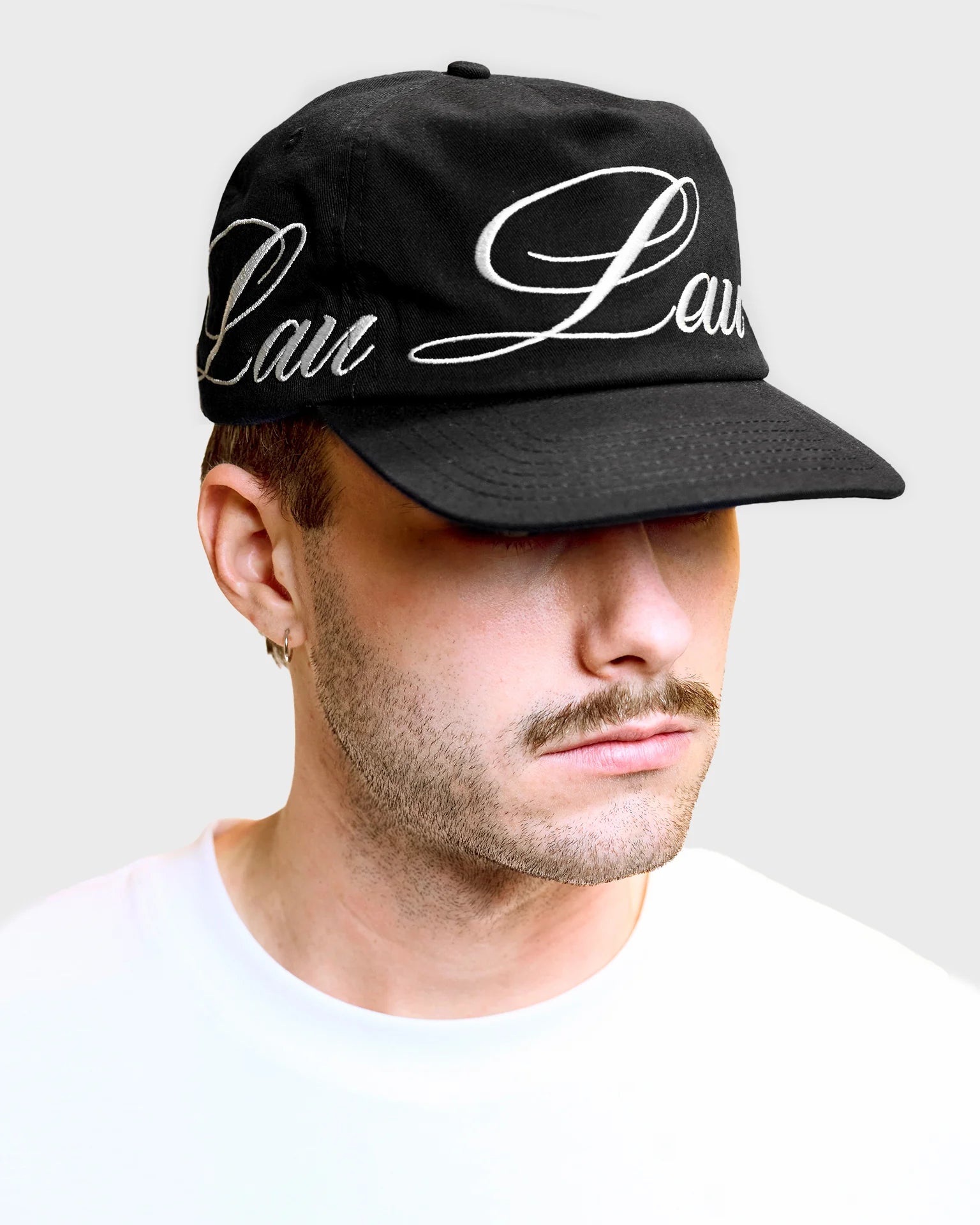 Lau Lau baseballkasket i sort med loop-design, afslappet stil, lavet af blødt materiale, vist fra siden.
