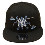 Sort og lyseblå New Era 9FIFTY snapback-hat med Yankees- og 1962 World Series-embossing, vises i et billede.