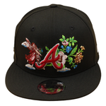 Sort og pink New Era 9FIFTY snapback cap med Atlanta Braves logo og blomstermotiv, UV beskyttelse, i billedet.