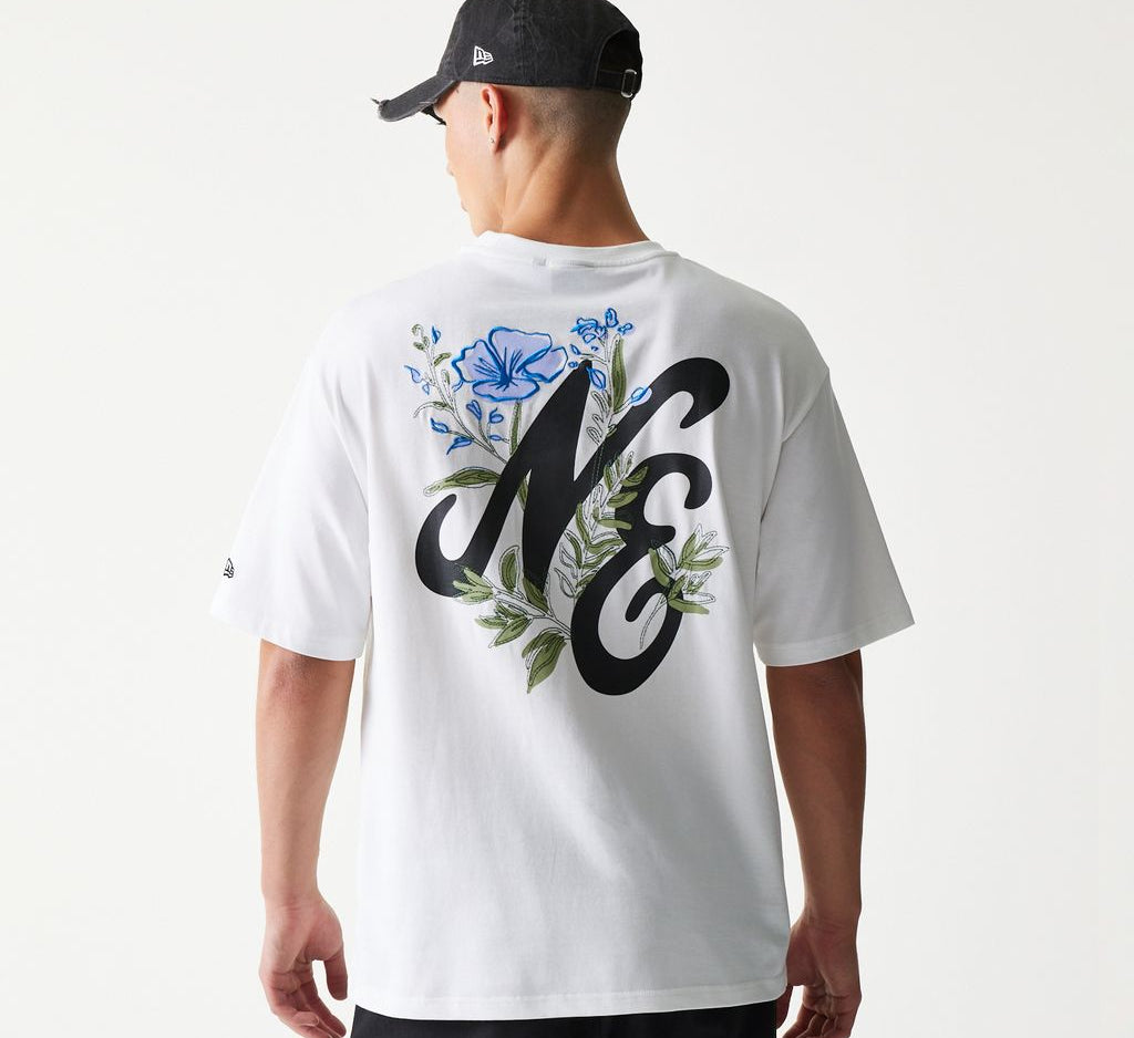 Hvid New Era T-shirt med stort blomstergrafik-design, oversized pasform og logo fra New Era.