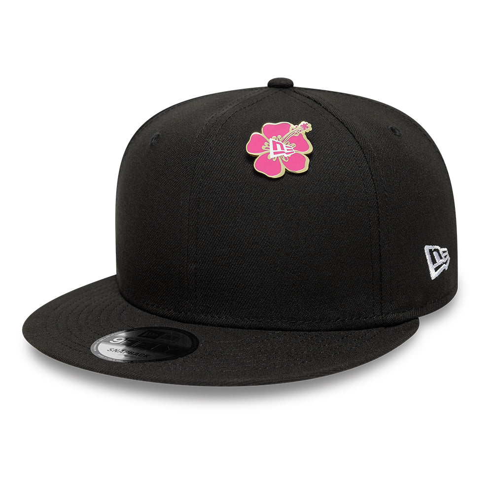 Guld New Era Flower pin badge fastgjort på taske med blomsterdesign og logo, elegant tilbehør til tasker.