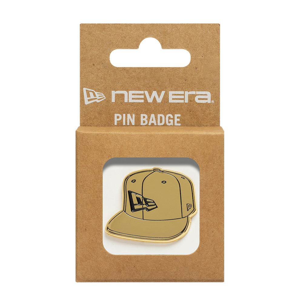 Gullfarget New Era NE Cap Badge, taskeaccessory med logo, synlig på billedet.