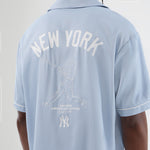 Lyseblå New Era NE GRAPHIC REVERE T-shirt med logo og grafiske detaljer, afslappet og stilfuld til hverdag.