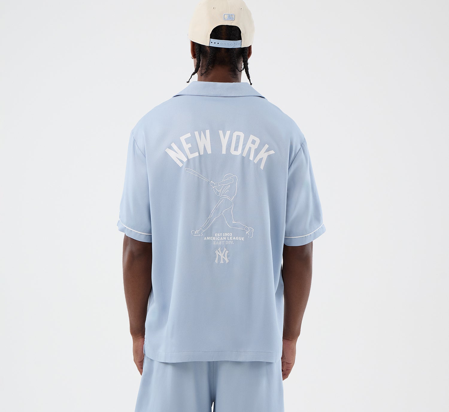 Lyst blå T-shirt fra New Era med grafisk design, blød bomuldsstof og komfortabel pasform.