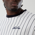Hvid og navy New Era oversize T-shirt med pinstripes, afslappet pasform og logo detaljer, set fra front.