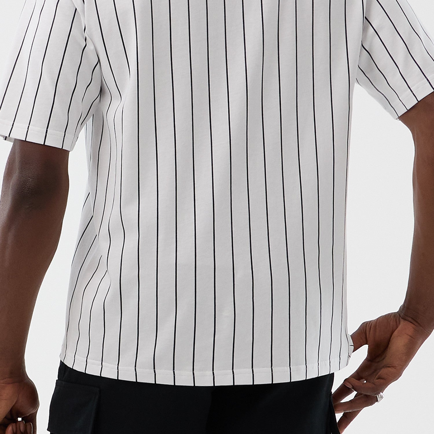 Hvid og navy New Era oversize T-shirt med pinstripes, afslappet stil, synlige striber og logo på fronten, casual dagligt brug.