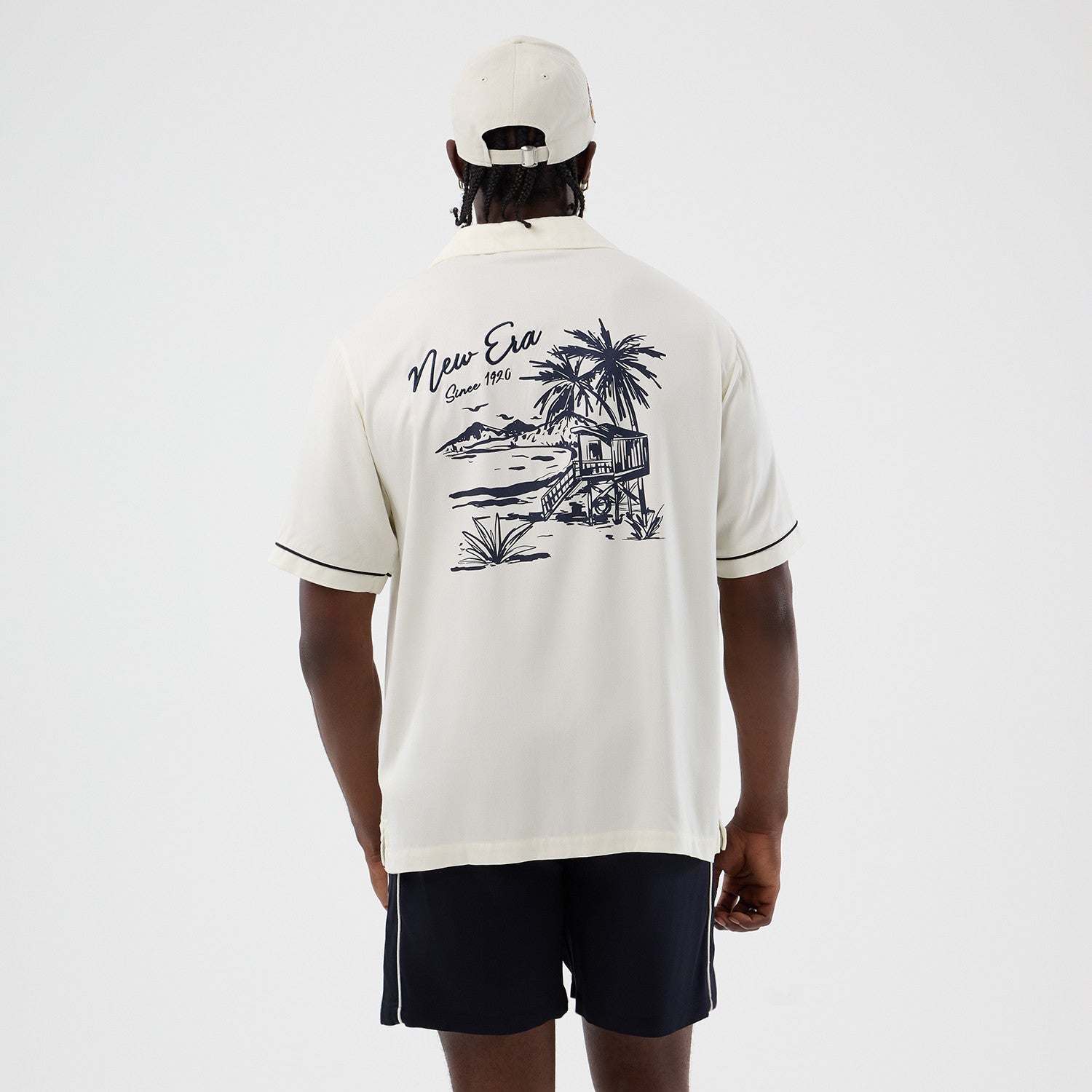 Off-white New Era T-shirt med grafisk design og New Era logo, afslappet og stilfuldt til hverdag.