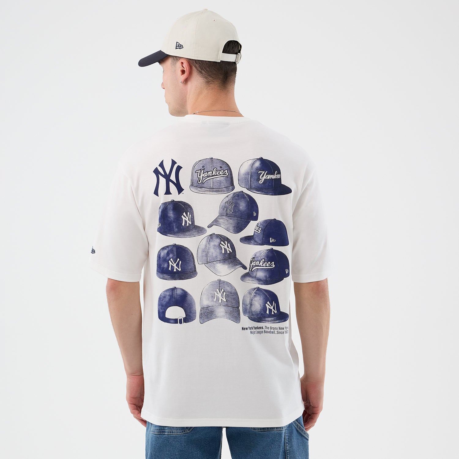 Hvid New Era MLB-cap grafisk T-shirt med oversized pasform og Yankees-logo, detaljeret visning af design og stoffets tekstur.