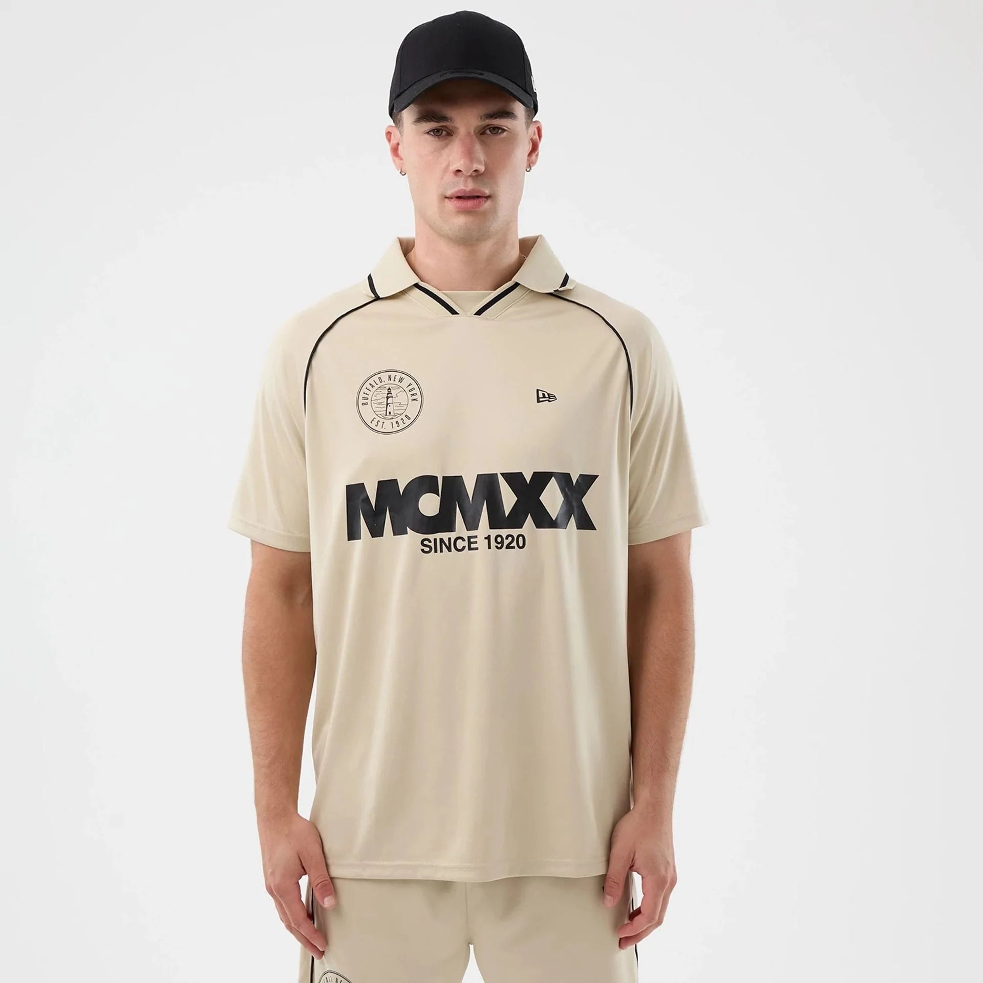 Hvid New Era fodbold T-shirt i stenfarve med rund hals og logo, vist på en model.