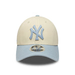 New Era Yankees 9FORTY cap i beige og lyseblå med side-tekst, afslappet baseballkappe med justerbar rem.