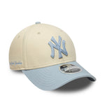 Beige og lyseblå New Era 9FORTY New York Yankees cap med side-tekst, afslappet sportsstil, foran og synligt mærke.