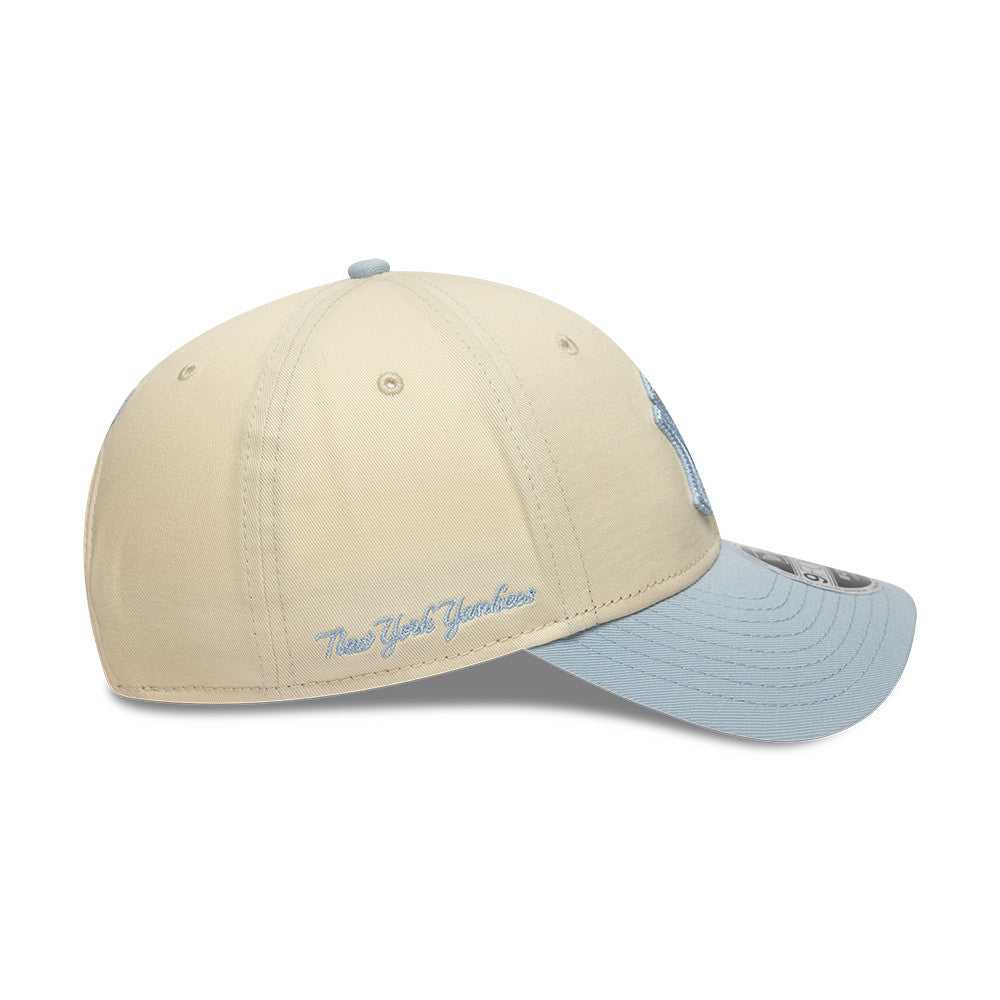 Beige og lyseblå New Era 9FORTY New York Yankees cap med side script-embossing, afslappet sportstil.