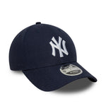 Navy New Era 9FORTY M-CROWN cap med New York Yankees logo, lavet af linned, foran set i close-up.