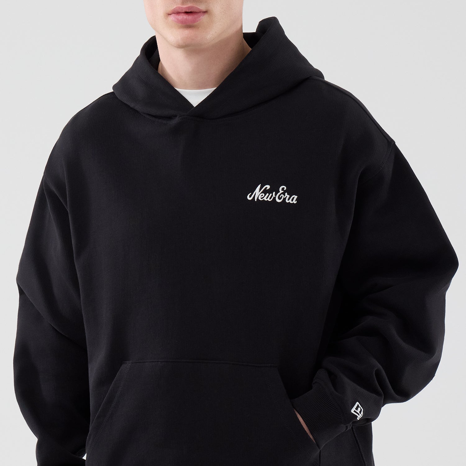 Sort New Era hoodie med åbent kantdesign og hætte, blødt bomuldsmateriale, perfekt til afslappet stil.