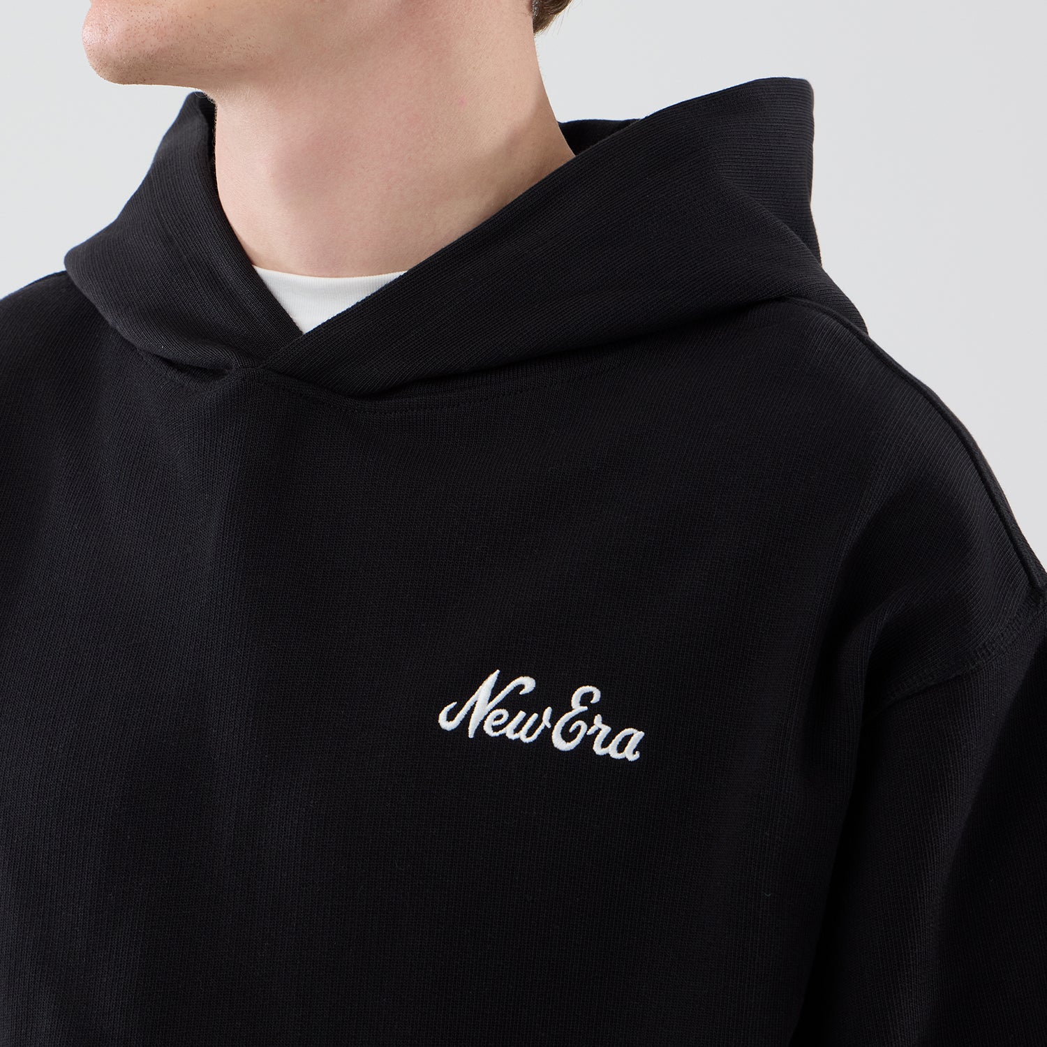 Sort New Era hoodie med åbent kantdesign, komfortabel crewneck i blødt materiale, afslappet stil.
