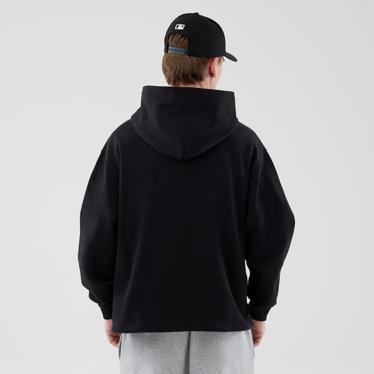 Sort New Era hoodie med åbent bundstykke og hætte, blødt bomuldsstof, perfekt til afslappede outfits.