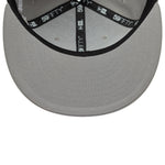 Grå New Era 59FIFTY Fitted New York Yankees cap med scribble-design, foran set fra siden.