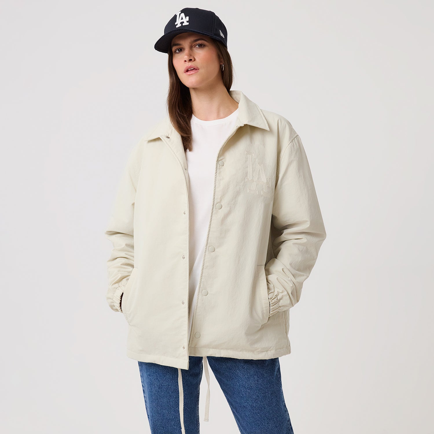 Beige New Era MLB Coachesjakke med logo og lommer, afslappet og sporty jakke til baseballfans.