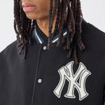 Sort New Era MLB DS Varsity-jakke med ærmer og knapper, klassisk sportstil, synlige logoer og detaljer.