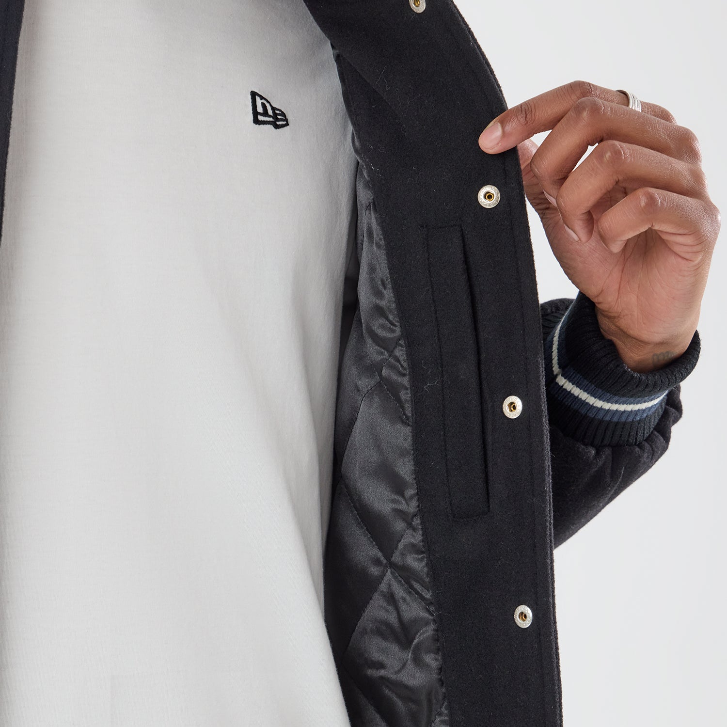 Sort New Era MLB DS Varsity-jakke med raglanærmer og foret, fremvist i et close-up billede.