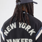 Sort New Era MLB DS Varsity-jakke med raglanærmer og broderet logo foran, sporty basketball-inspireret design.