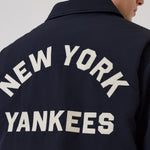 Navy New Era New York Yankees MLB trænerjakke med logo, lavet af slidstærkt materiale, vist på bøjle.