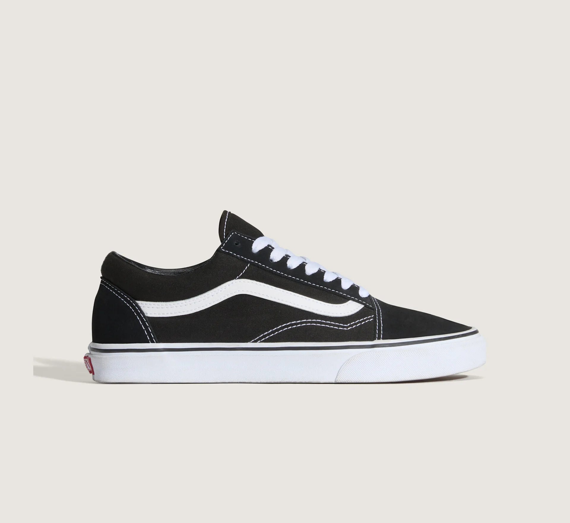 Sort og hvid VANS Old Skool sko med lav hæl og klassisk design, synlig med snørebånd og logo på siden