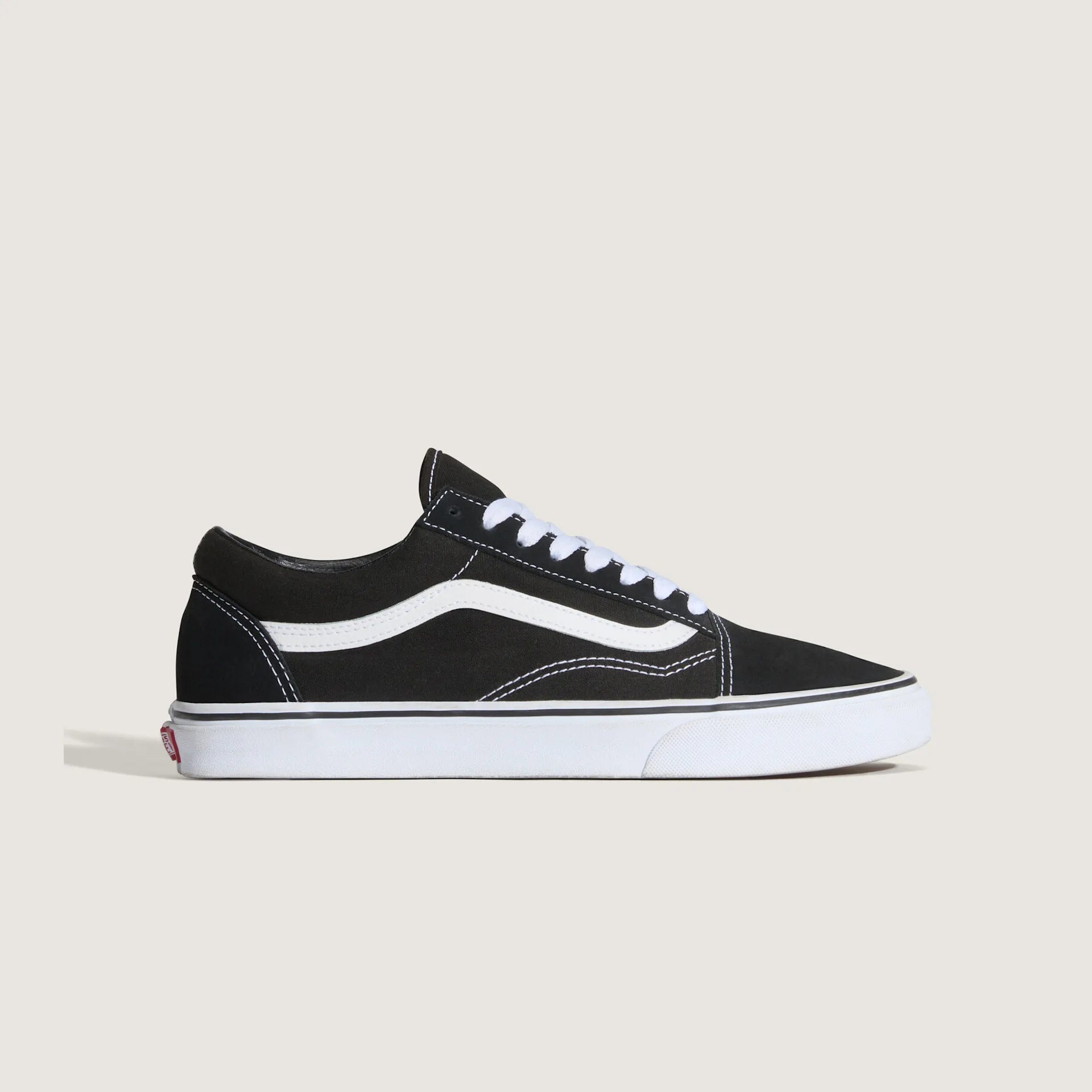 Sort og hvid VANS Old Skool sko med lav hæl og klassisk design, synlig med snørebånd og logo på siden