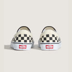 Sort og hvid checkerboard VANS sneakers i slip-on stil, vist fra siden med synlige elastikindlæg og flad sål.
