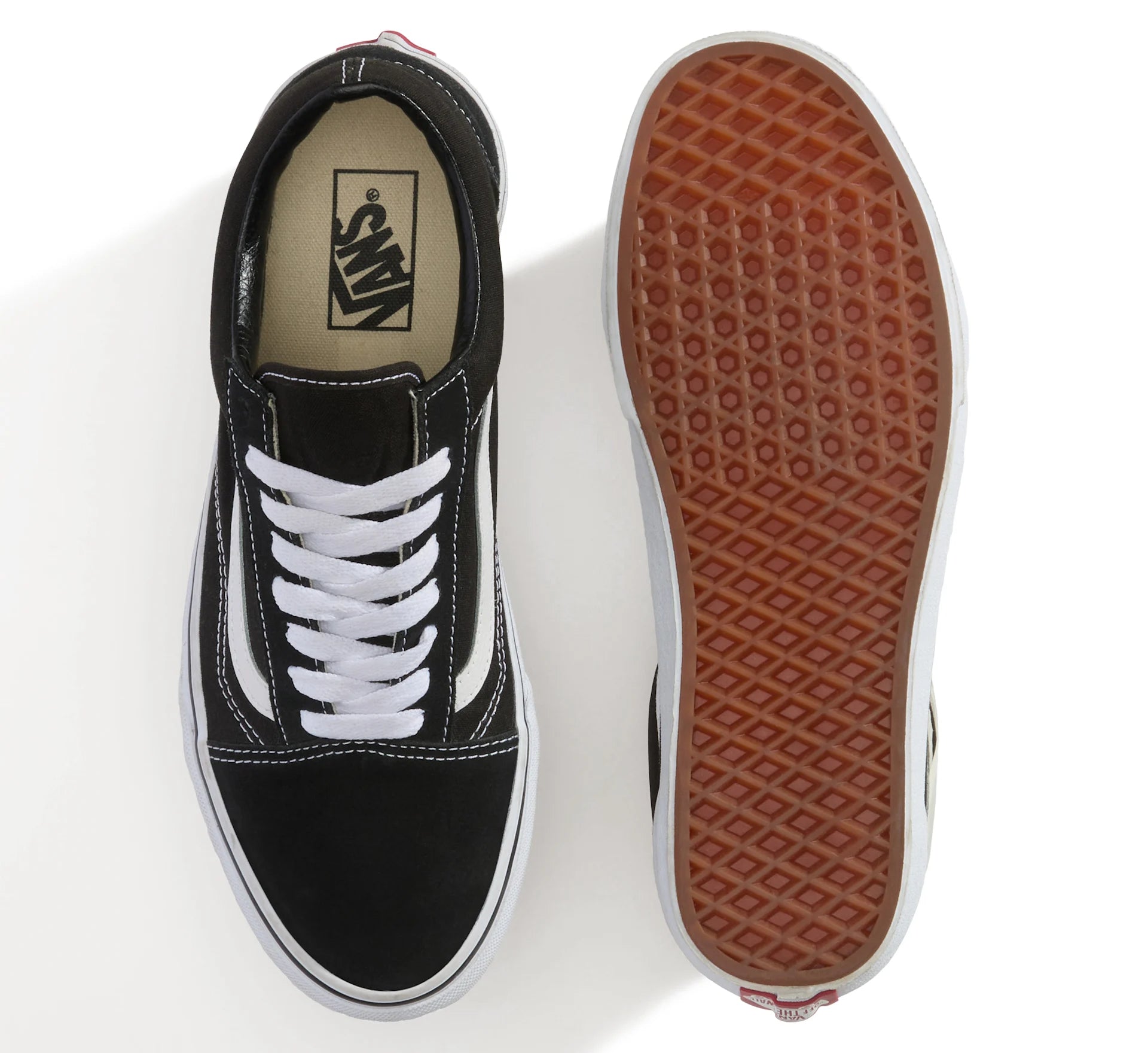 Sort og hvid VANS Old Skool sko med lav top og klassisk design, vist på en model foran en neutral baggrund.
