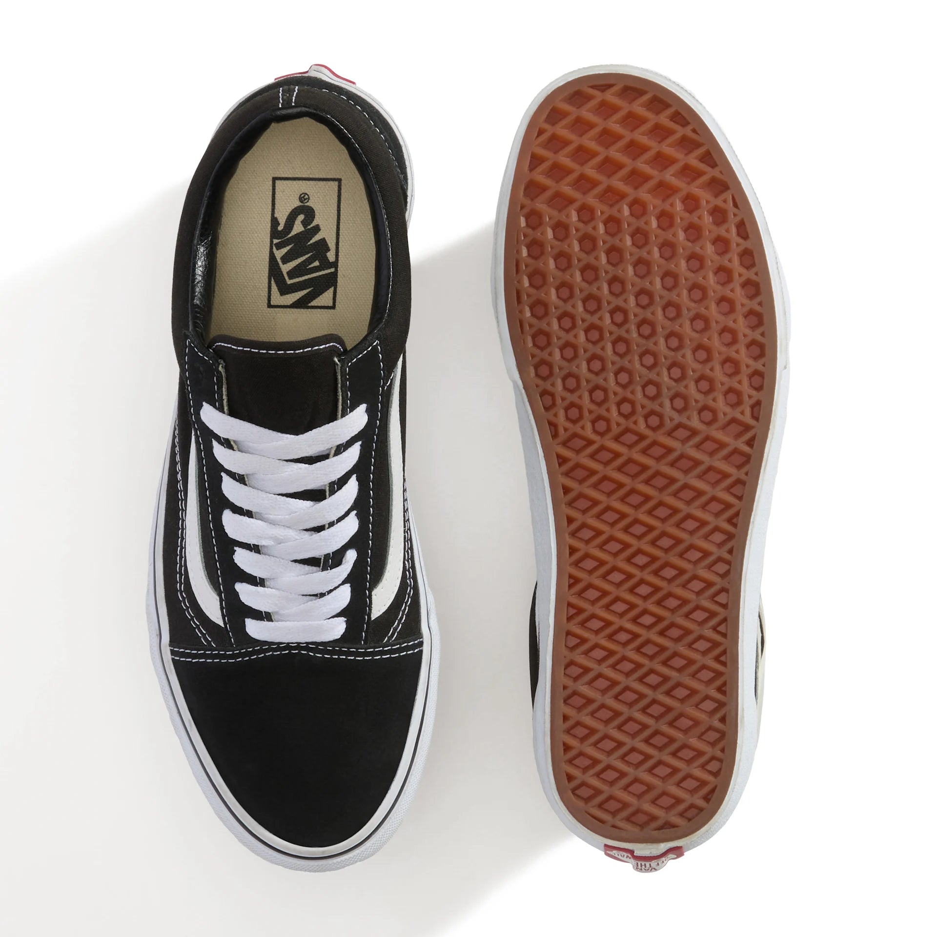 Sort og hvid VANS Old Skool sko med lav top og klassisk design, vist på en model foran en neutral baggrund.