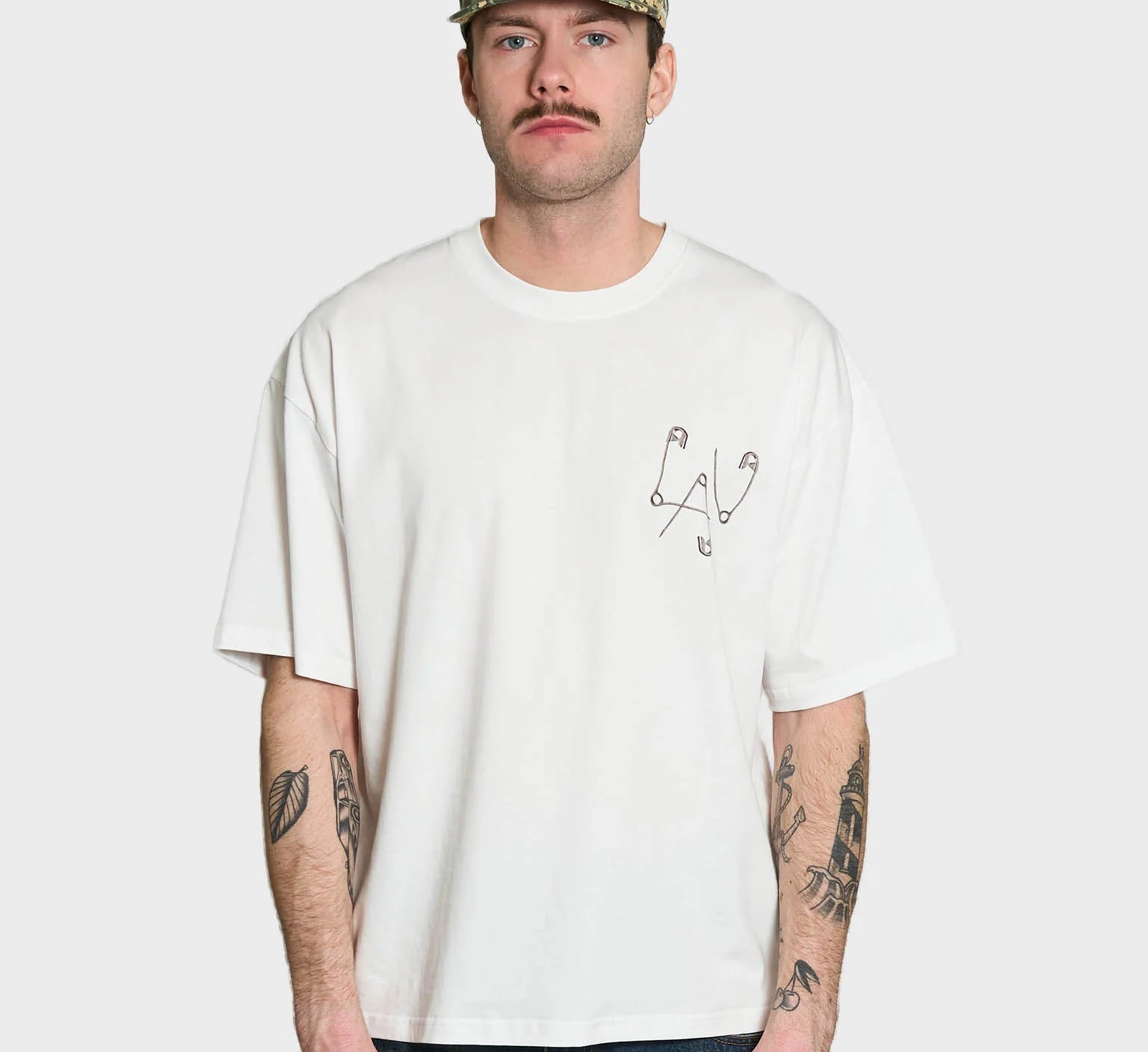 Lau Lau Safety Pin Tee SS i hvid, kortærmet T-shirt med sikkerhedsnålsdetaljer, afslappet casual stil, foran vises logo.