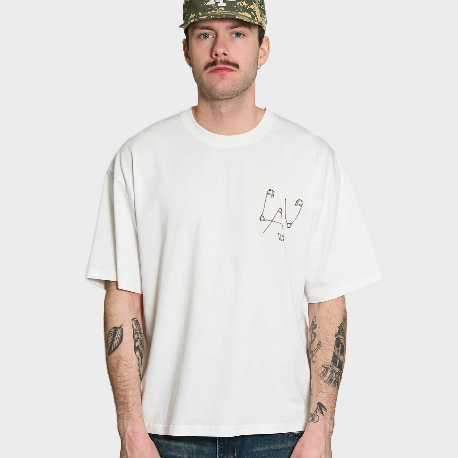 Lau Lau Safety Pin Tee SS i hvid, kortærmet T-shirt med sikkerhedsnålsdetaljer, afslappet casual stil, foran vises logo.