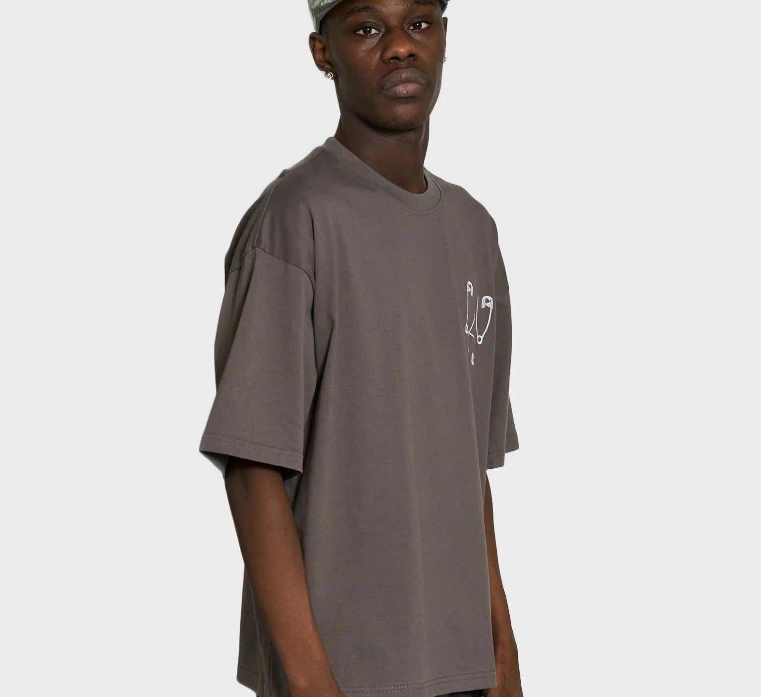 Grå Lau Lau Safety Pin T-shirt med kort ærme, blød bomuldsstof, afslappet pasform og sikkerhedspins design.