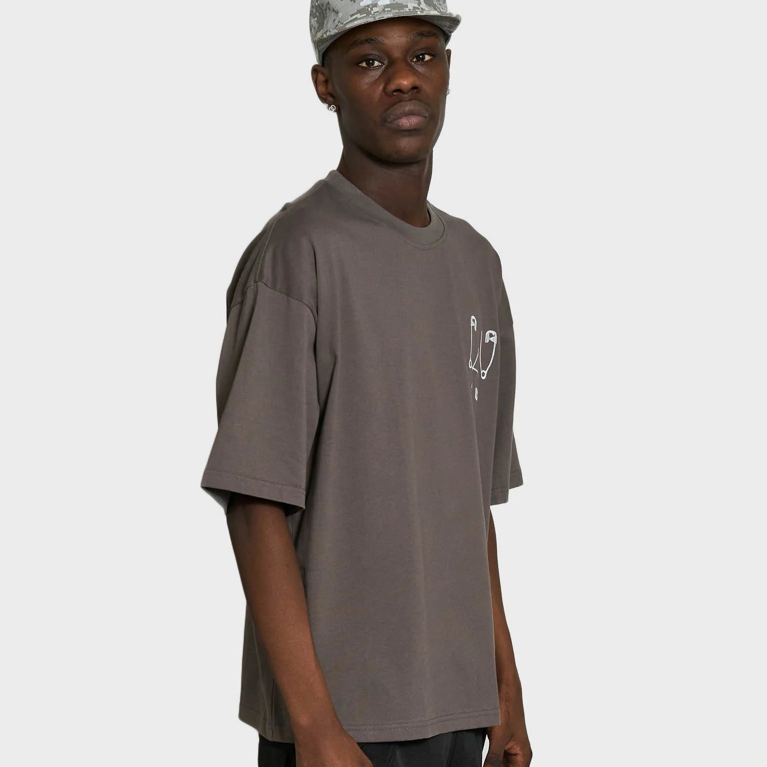 Grå Lau Lau Safety Pin T-shirt med kort ærme, blød bomuldsstof, afslappet pasform og sikkerhedspins design.