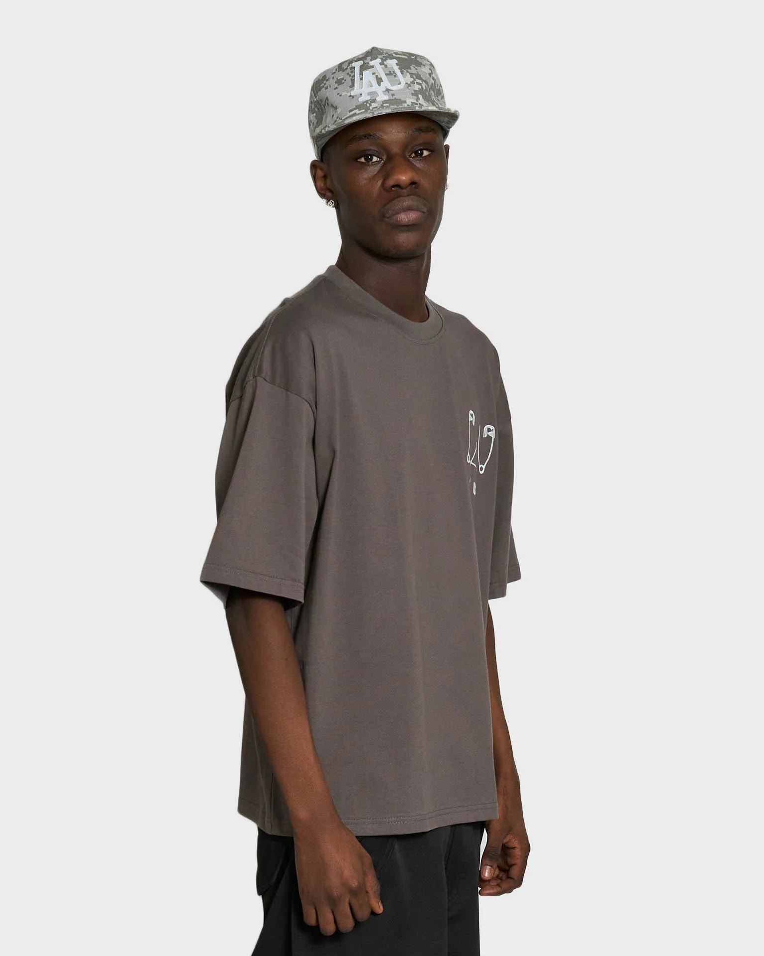 Grå Lau Lau Safety Pin T-shirt med kort ærme, blød bomuldsstof, afslappet pasform og sikkerhedspins design.