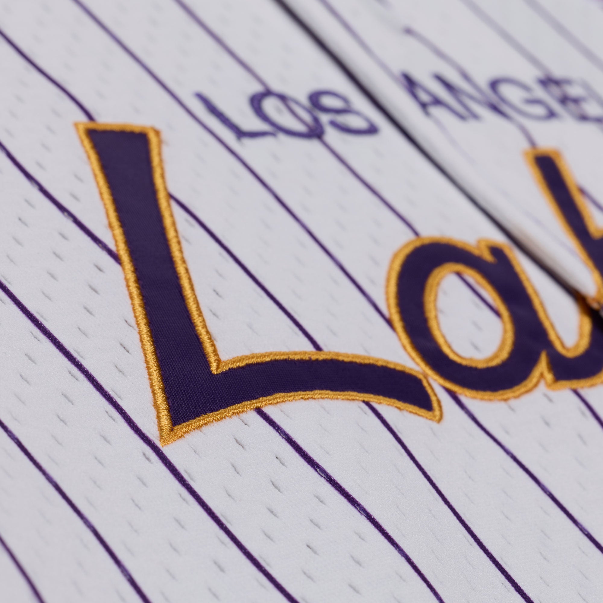 Mitchell & Ness Los Angeles Lakers hvid striped mesh T-shirt med knap foran og logo, sports- og basketball-inspireret.