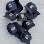 BLS klassisk baseballkasket i mørk navy med hvide detaljer, blødt stof og justerbart bånd foran.