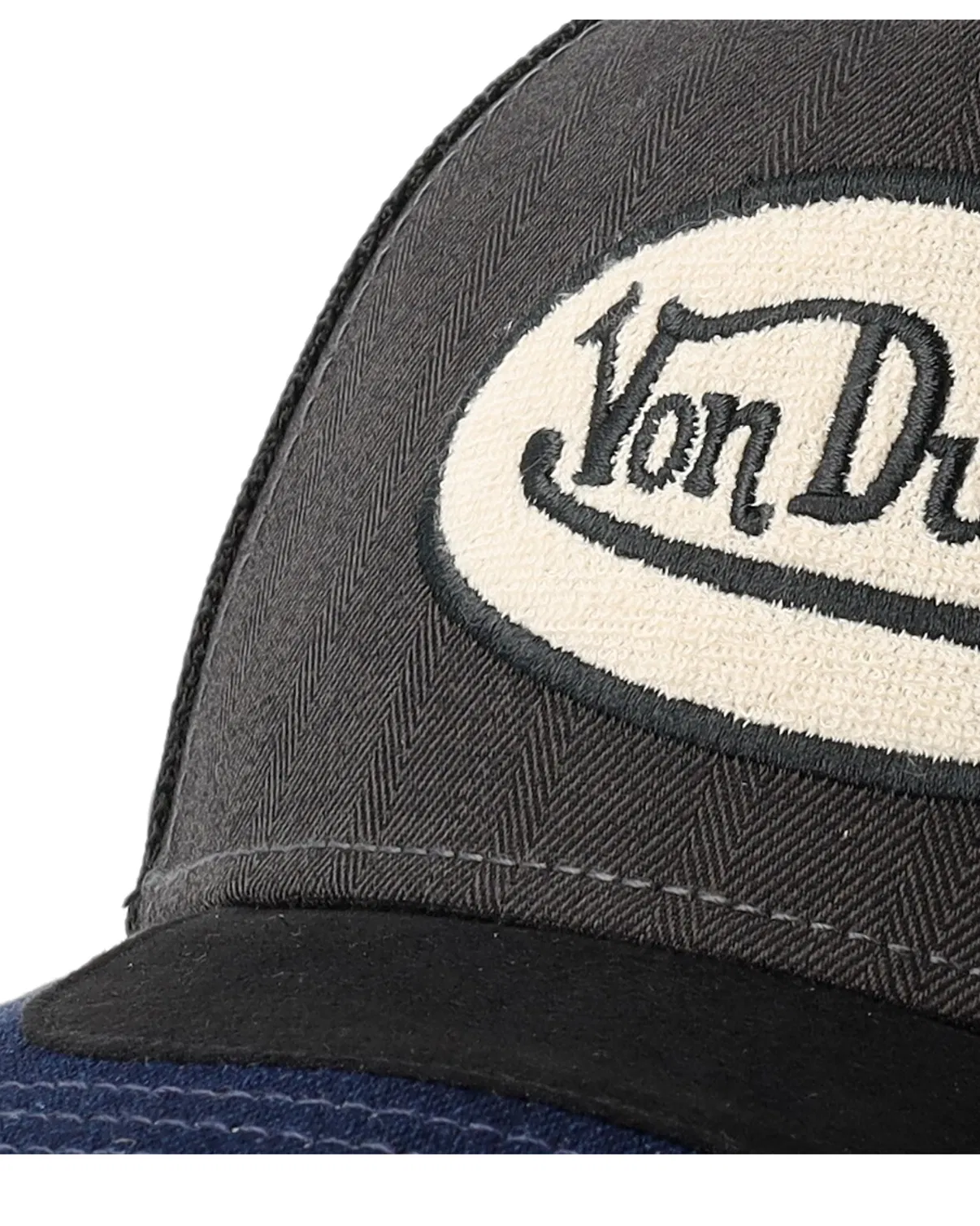 Von Dutch trucker cap med oval patch, skjolddesign i grå, sort og navy, klassisk cap med justerbart bånd.
