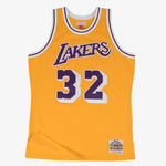 Mitchell & Ness Swingman Magic Johnson 1984 basketball Jersey i lyseguld farve, vises på model med fokus på logo og detaljer