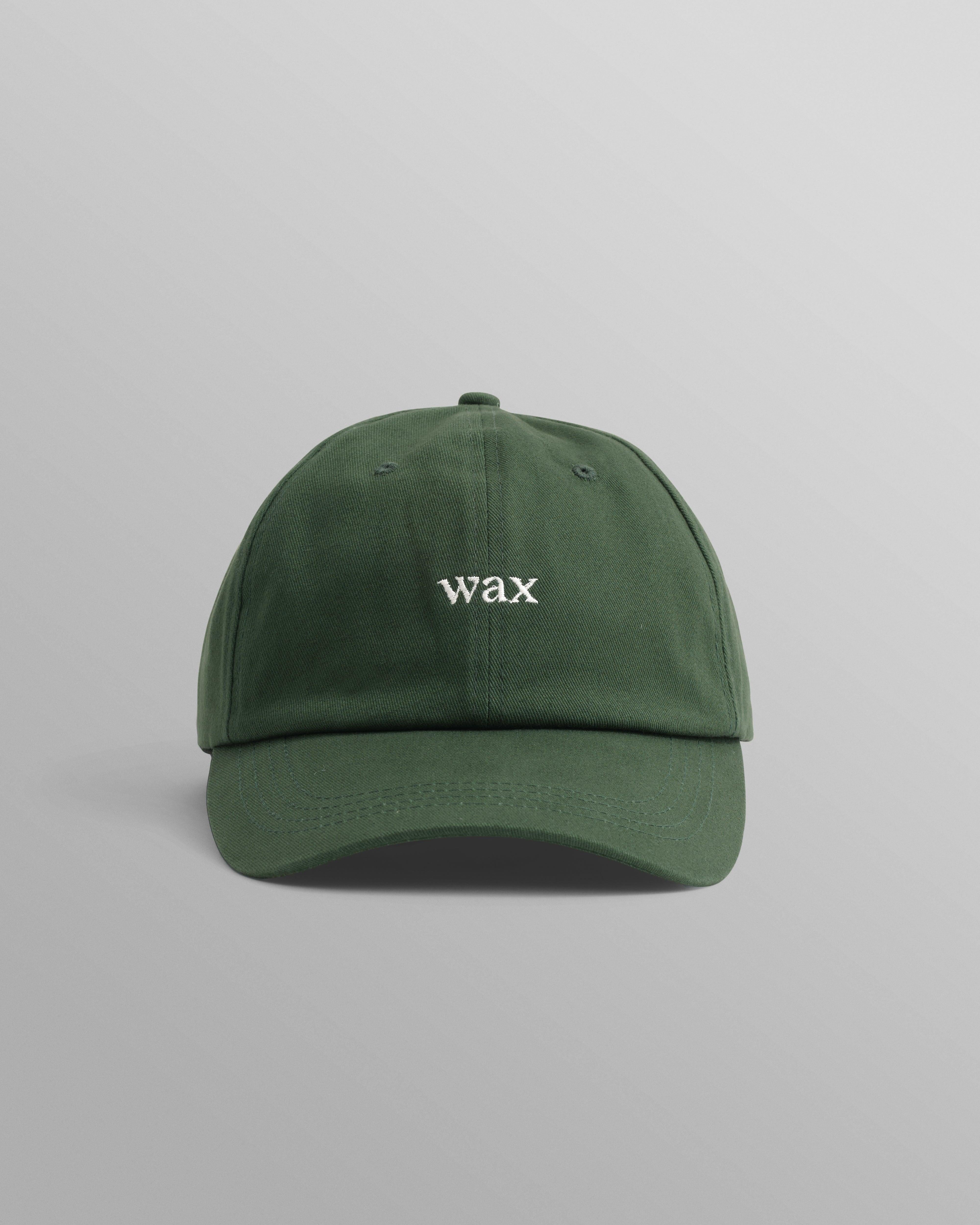 Grøn sportskasket af bomuld fra Wax London, Spencer-modellen, vist med tydelige visuelle detaljer og logo.