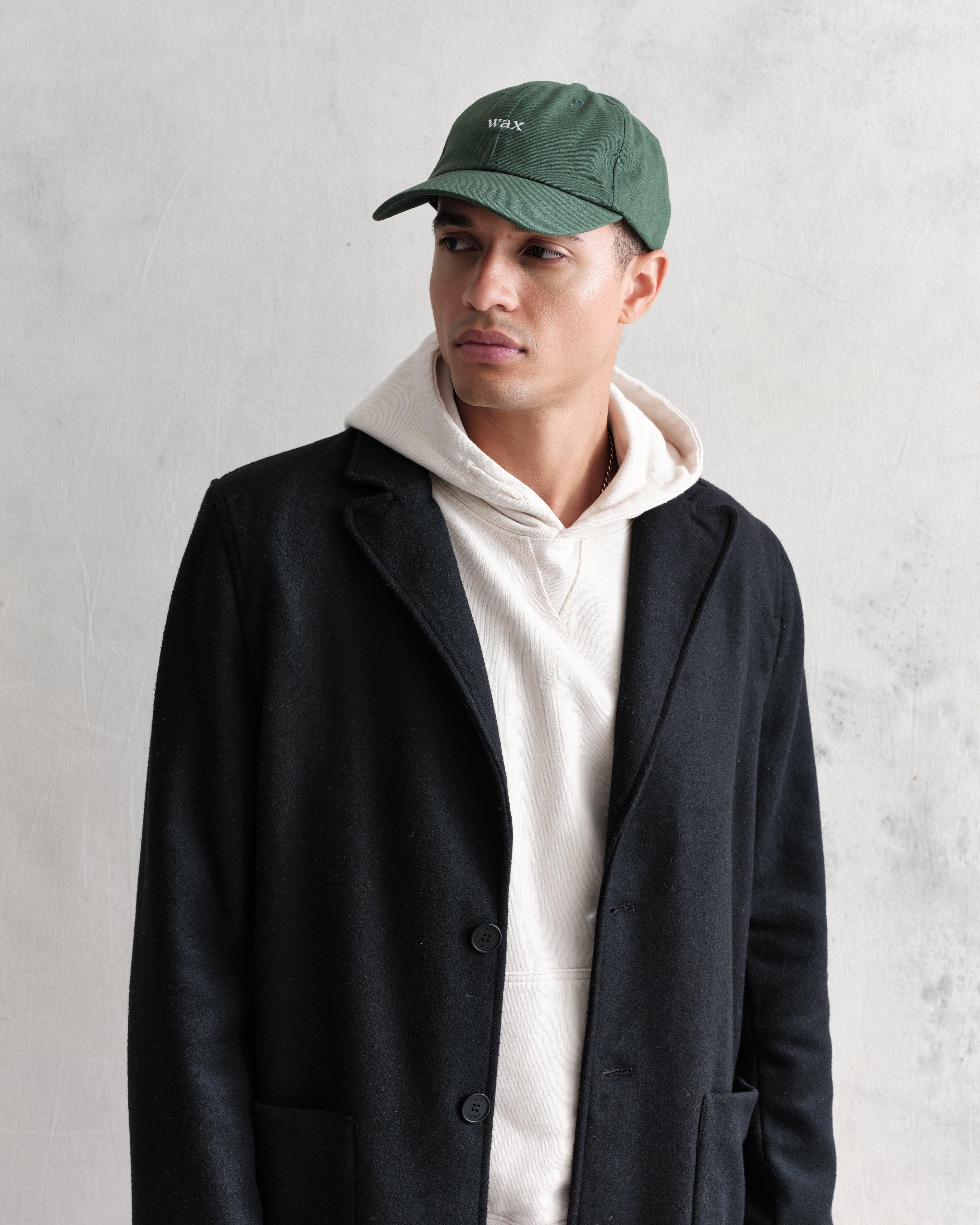 Grøn sportskasket af bomuld fra Wax London, Spencer-model, vist på billedet.