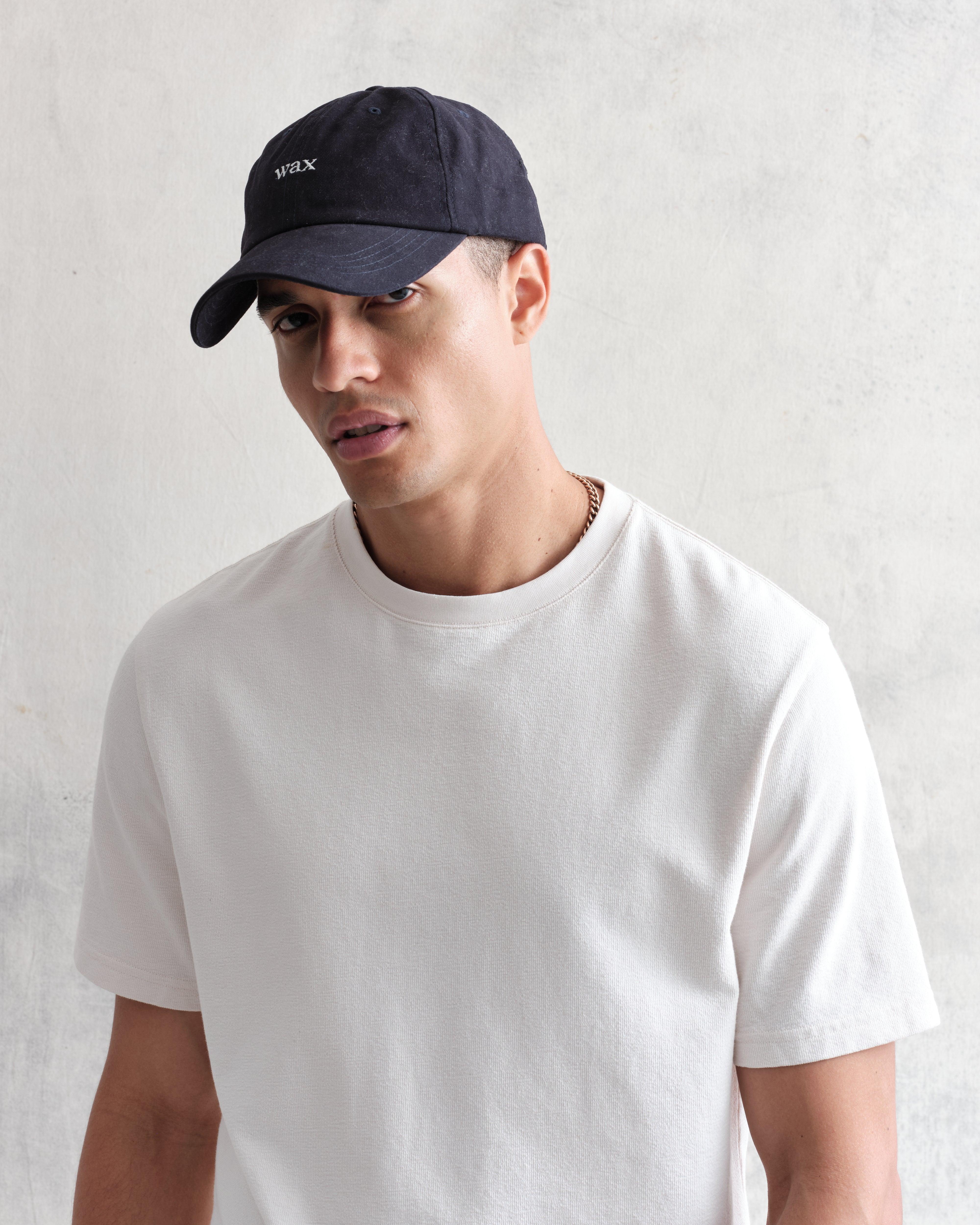 Navy Spencer sport cap fra Wax London med bomuld, afslappet stil, synlig i et klart billede.