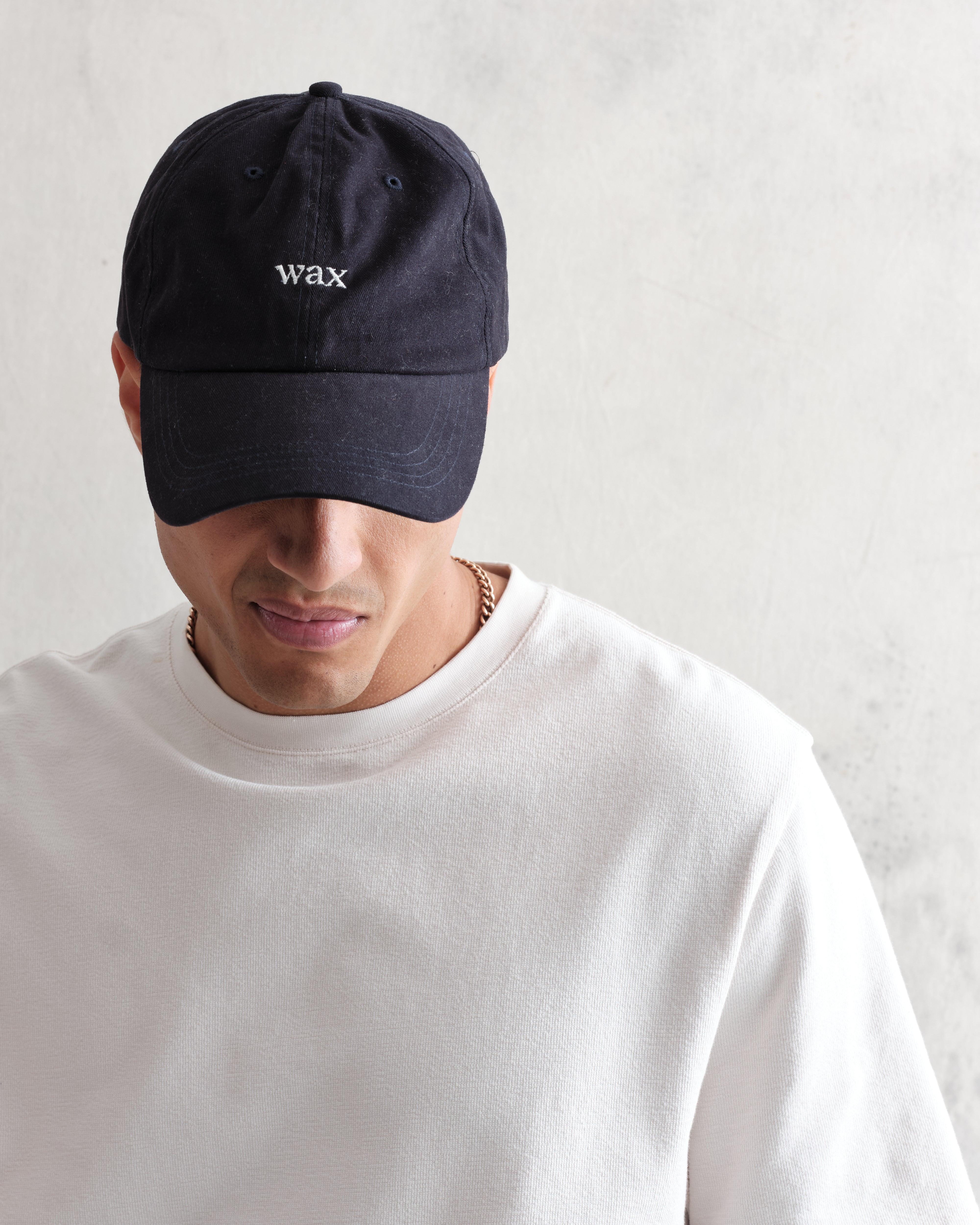 Navy Spencer sport cap fra Wax London i bomuld med justerbar rem og sporty design, vist foran på modellen.
